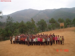 学生们在泥巴操场上集合，背后是歪歪斜斜的篮板，听校长安排事情，他们多么希望有一天能有一块水泥操场和一对象样的篮板啊。