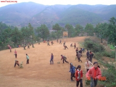 学生们的一堂劳动课。看，树枝也能做扫帚呢。因为是泥巴操场，一扫起来可是尘土飞扬。